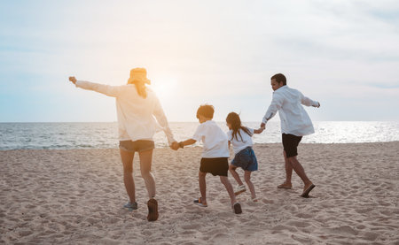 La familia asiática feliz disfruta de la playa del mar en el padre, la madre, el hijo y la hija que se divierten jugando a la playa en las vacaciones de verano en la playa del océano. familia feliz con el concepto de estilo de vida de tiempo de vacaciones. Foto de archivo