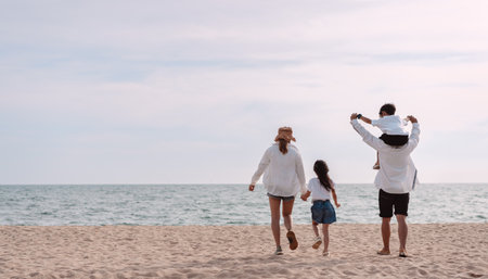 Familia asiática feliz en la playa de vacaciones. de la familia tomados de la mano, hijo e hija a cuestas de los padres. se divierten jugando disfrutando en la playa. concepto de familia y estilo de vida de verano.