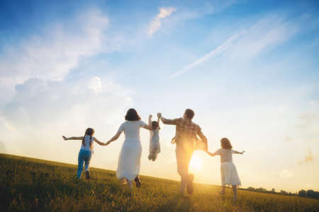 ¡Familia feliz en paseo de verano! Madre, padre e hijas paseando por el parque y disfrutando de la hermosa naturaleza.