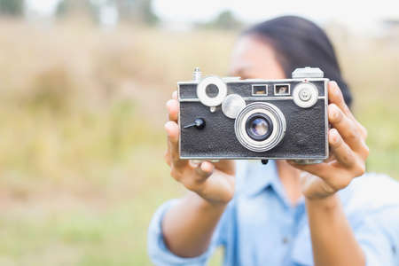 Woman photographed in a meadow with a camera