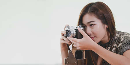 Beautiful professional photographer taking a photo with camera inside the comfortable room