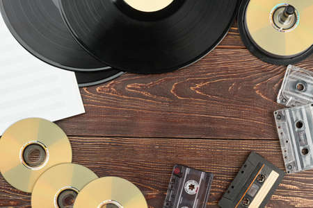 Fotograma de discos y discos musicales antiguos. Discos de vinilo, discos compactos, casetes analógicos, notas musicales y espacio de copia. Dispositivos de almacenamiento de música retro.