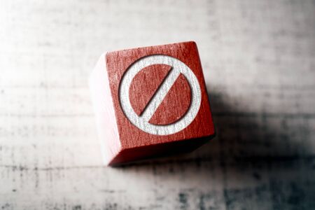 Prohibition sign on red wooden block on a table