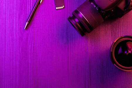 Camera pen fish eye lens and sd card pink light workspace top view copy space wood background Stock Photo