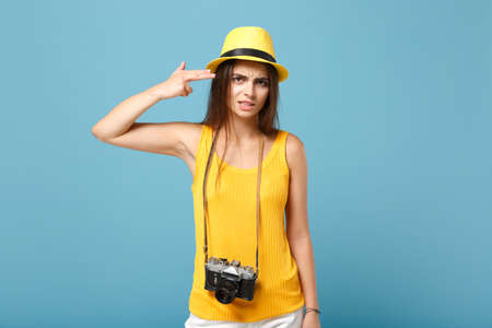 Traveler tourist woman in yellow summer casual clothes hat with photo camera isolated on blue background female sad passenger traveling abroad to travel on weekends getaway air flight journey concept