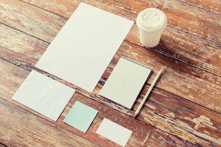 Business education and objects concept close up of notebook coffee cup pencil and papers on table