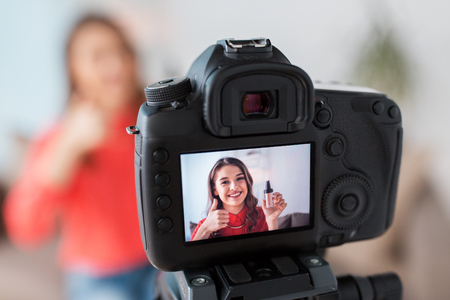 Woman with foundation and camera recording video Stock Photo