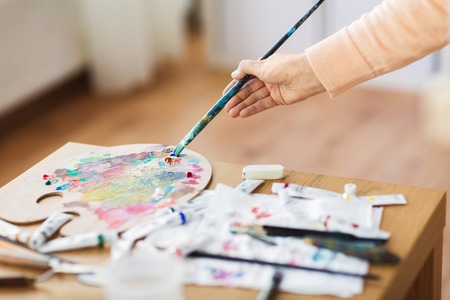 Artist hand with paintbrush and color palette