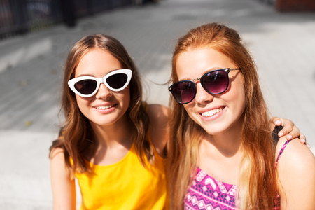 Smiling teenage girls in sunglasses outdoors Stock Photo