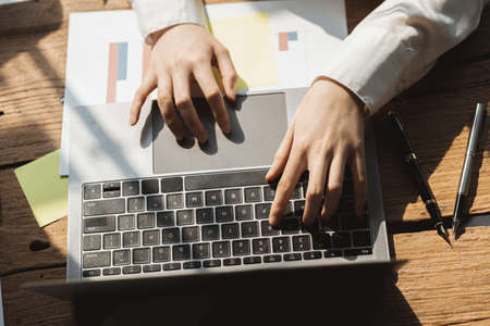 Close up of hands resting on keyboard to view financial data business growth in the world of cryptocurrencies and the current global economy with war and volatility finance and investment concepts Stock Photo