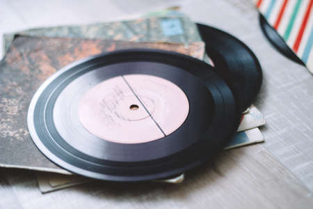 una pila de discos viejos de vinilo en un piso de madera