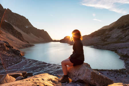 Avontuurlijke blanke volwassen vrouw Wandelen op de top van een Canadese Rocky Mountain. Sunny Zomer Sunset. Wedgemount, Whistler, British Columbia, Canada.