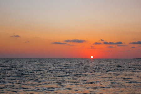 Puesta de sol sobre el mar, sol rojo en la superficie del agua