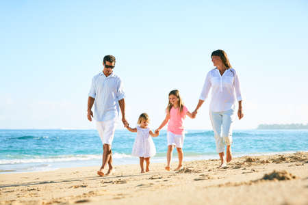 Feliz familia disfrutando de caminar en la playa Foto de archivo