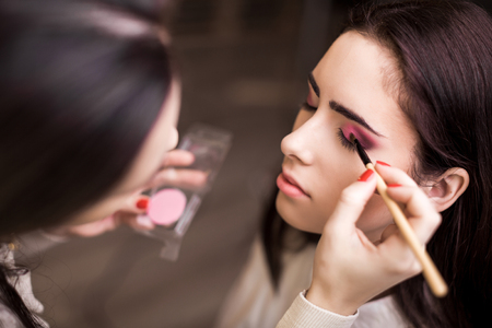 Makeup artist apply makeup to a model