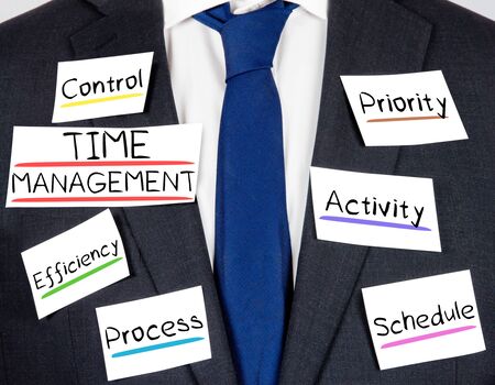 Photo of business suit and tie with time management conceptual words written on paper cards Stock Photo