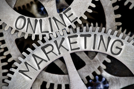 Macro photo of tooth wheel mechanism with online marketing letters imprinted on metal surface