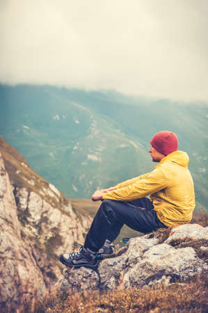 Man traveler relaxing alone in mountains travel lifestyle concept cloudy nature landscape on background