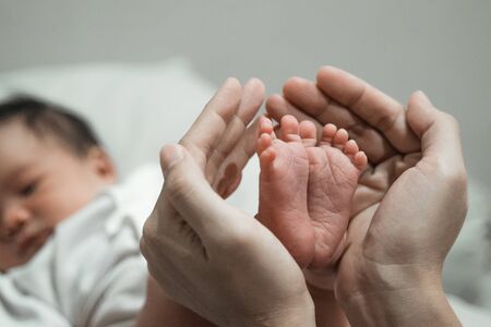 Mother hands holding baby feet