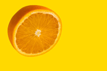 Orange cut in half isolated on yellow background with copy space Stock Photo