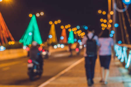 Young couple on the background busy traffic on a bridge at night glowing bridge supports blurred focus