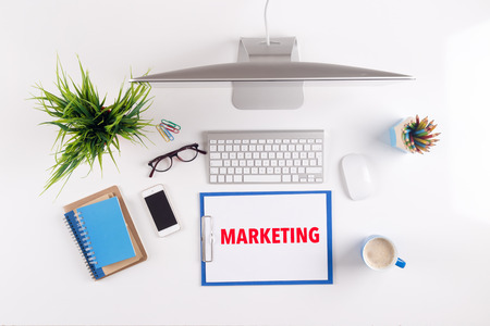 Office desk with marketing paperwork and other objects around top view