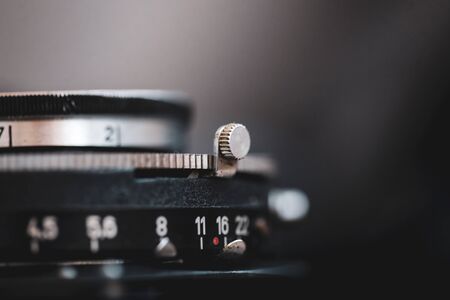 Macro and shallow depth of field image selective focus with the markings on the lens of a very old bellows photo camera exposure time and f stops