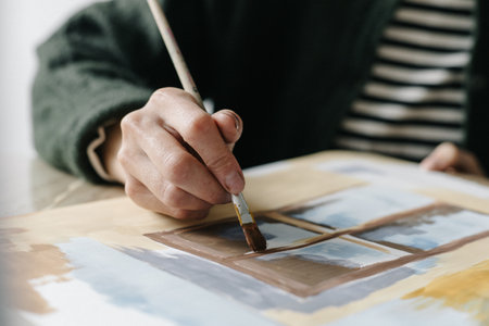 Woman paints with a brush paints on a sheet