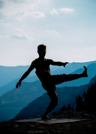 Profile view of a male urban dancer practicing some dance moves and jumping outdoors