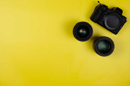 Black mirrorless camera with a lens on a yellow background