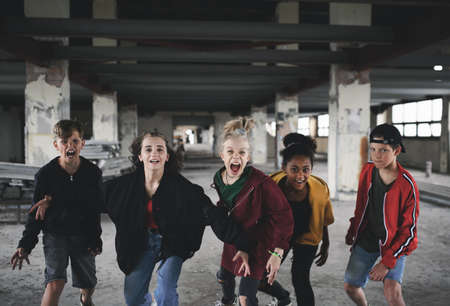 Group of teenagers girl gang standing indoors in abandoned building shouting