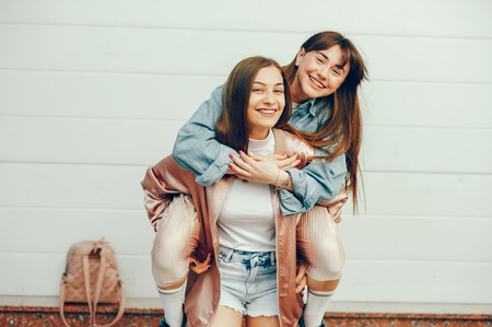 Dos hermosas chicas están caminando por la ciudad.