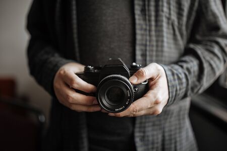 Male in shirt man hands holds retro camera horizontal close up