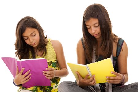 Two young student sisters reading books on the floor Stock Photo