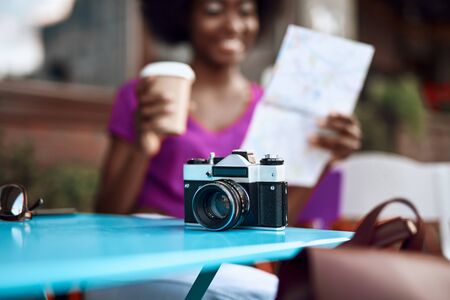 Happy african woman holding coffee and map in hands Stock Photo