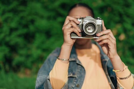 Young african american woman making photo at old camera Stock Photo