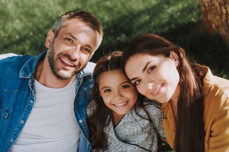 La familia sonriente está pasando un maravilloso fin de semana al aire libre