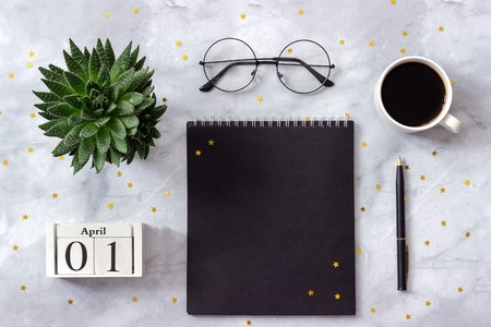 Office or home table desk wooden cubes calendar april 1st black notepad cup of coffee succulent glasses on marble background concept stylish workplace flat lay top view Stock Photo