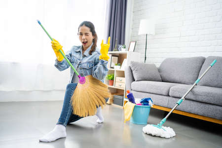 Mujer joven limpiando el piso en casa haciendo tareas. Ella disfrutaba de los deberes domésticos. Foto de archivo