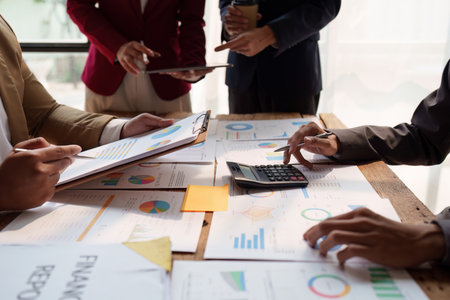 Close up of diverse colleagues gather brainstorm discuss financial statistics at office meeting finance teamwork big data graphs charts concept