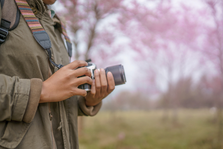 Hand holding camera with beautiful natural background