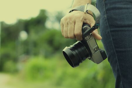 Woman hand holding digital camera isolated on white background with copy space