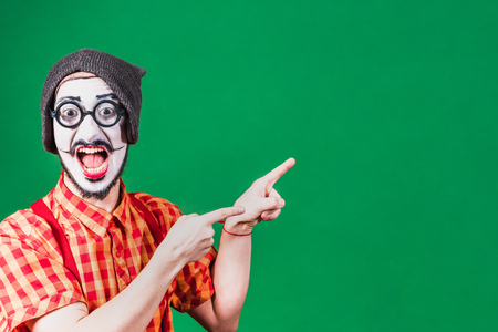 Funny mime poses near a green background