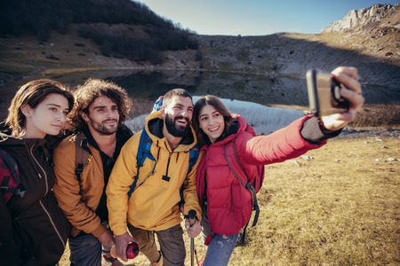 Grupo de excursionistas en una montaña en el día de otoño hacen foto selfie