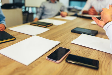 Business people sitting at desk with empty papers on desk