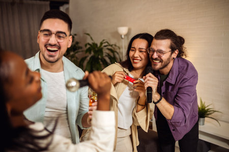 Multiracial group of friends having karaoke night singing in to the microphone drinking beer and playing mouth organ