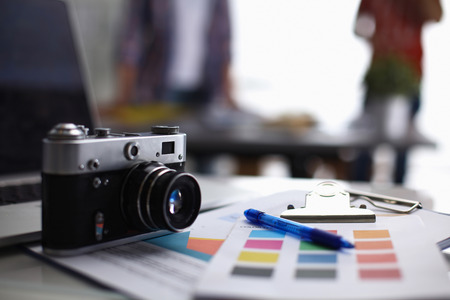 Laptop and camera on the desk with folder