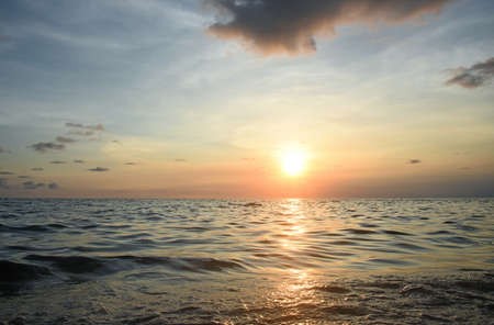 Puesta de sol naranja en el mar, reflejos brillantes en las olas Foto de archivo