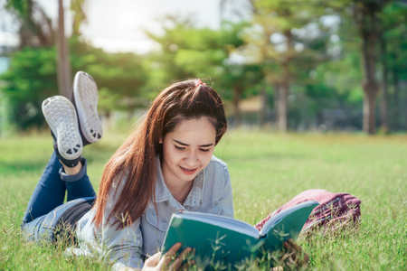 A group of teenage student in university smiling and reading the book in summer holiday Stock Photo