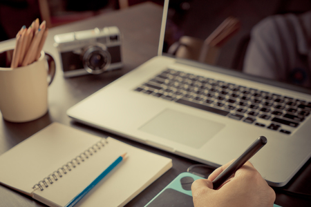 Photographer graphic designer working on drawing tablet on working desk